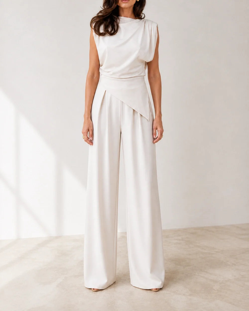 Women's white asymmetric draped top and wide-leg trousers set, straight front view.