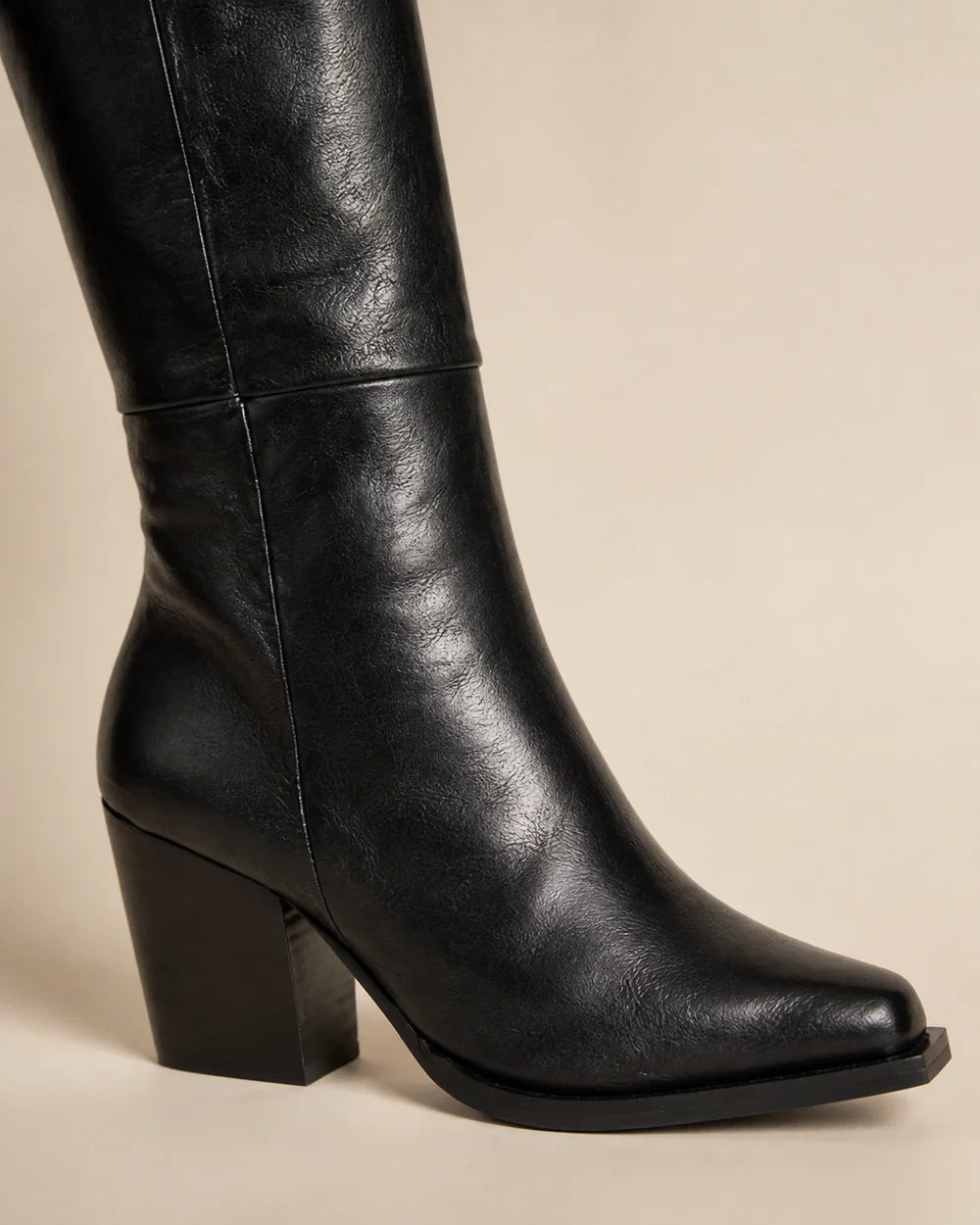 Black pointed-toe knee-high boots, detail view